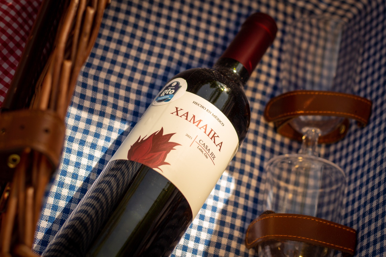 Fotografia de una botella de Xamaika dentro de una canasta de picnic